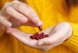 Person holding red vitamins in hand.jpg